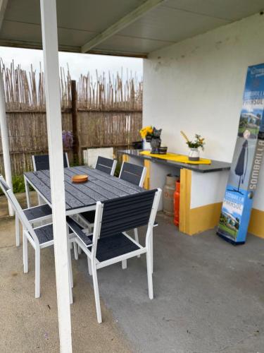 a table and chairs in a patio with a counter at Casinha em frente à Lagoa in Aldeia de Brescos