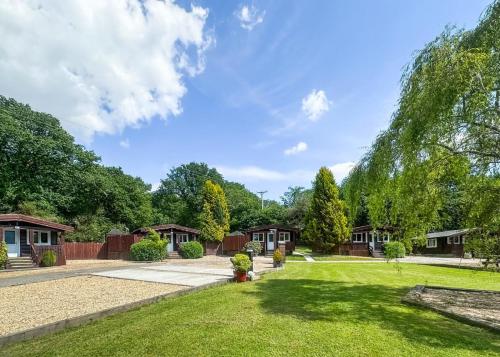 a yard with many cottages and trees at Heronstone Lodges in Ystalyfera