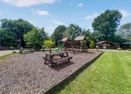 a park with a playground and a picnic table at Heronstone Lodges in Ystalyfera