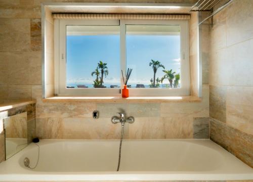a bath tub in a bathroom with a window at Villa Maya Bali Inspired Villa in Mijas