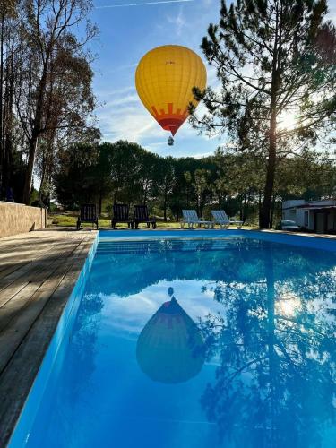 a hot air balloon flying over a swimming pool at Monte da Tojeirinha in Montargil