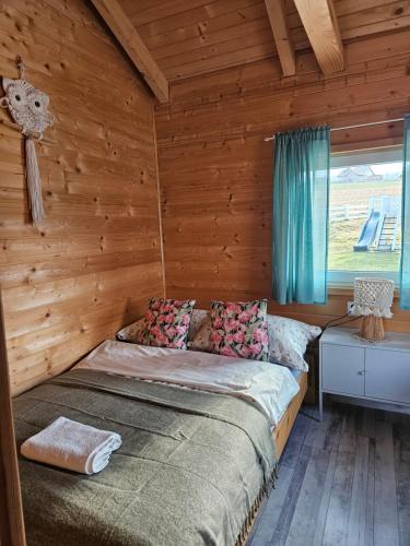 a bedroom with a bed in a wooden cabin at Domek Polna Cisza Bieszczady in Lesko