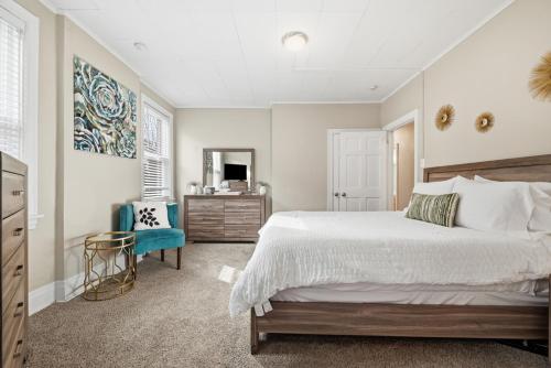a bedroom with a large bed and a blue chair at Spacious & Clean 3BR 2 Balconies Parking in Pittsburgh