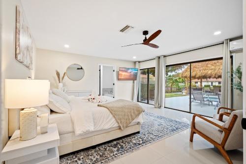 a white bedroom with a bed and a sliding glass door at Waterfront Oasis, Heated Pool, MiniGolf, TikiHut in Lake Clarke Shores