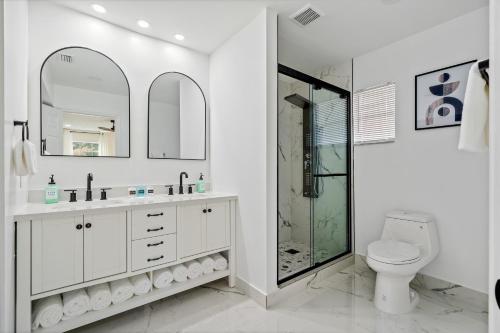 a white bathroom with a shower and a toilet at Waterfront Oasis, Heated Pool, MiniGolf, TikiHut in Lake Clarke Shores