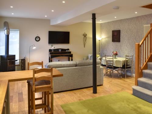 a living room with a couch and a dining room at Barn End in Pooley Bridge