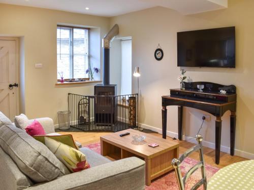 a living room with a couch and a piano at Barn End in Pooley Bridge