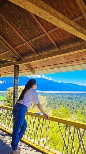 a woman standing on a balcony looking out at the desert at Nature's Harmony Heaven Resort in Dāmbuk