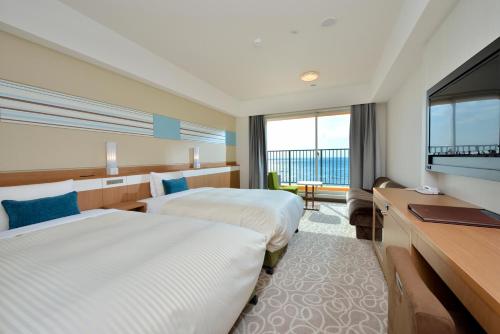 a hotel room with two beds and a flat screen tv at Vessel Hotel Campana Okinawa in Chatan