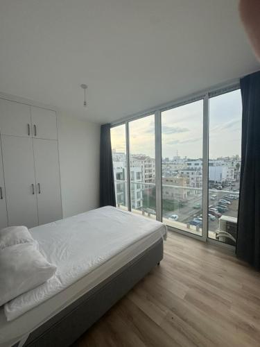 a bedroom with a bed and a large window at Cyprus Apart Hotel in Famagusta