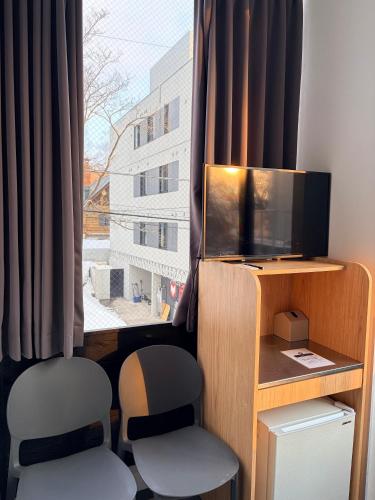 a room with two chairs and a tv and a window at Q FOX BLACK DIAMOND HOTEL in Kutchan