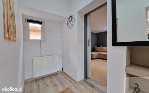 a white room with a hallway with a window and a couch at Atlantis villa in Ustka