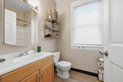 a bathroom with a sink and a toilet and a window at Spacious & Clean 3BR 2 Balconies Parking in Pittsburgh