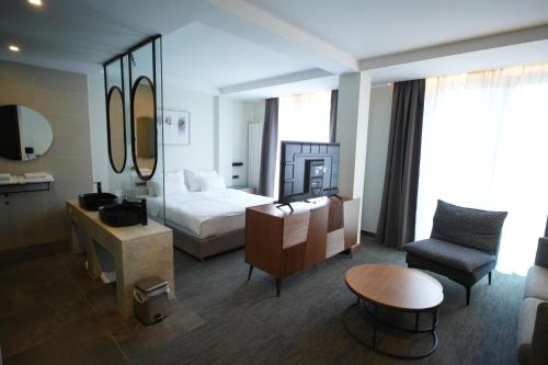a hotel room with a bed and a chair at Hotel Pljevlja in Pljevlja