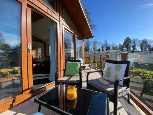 a porch with two chairs and a glass table at Sunset Lodge in Poole