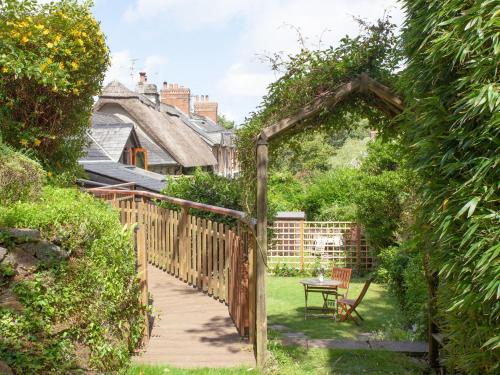 a garden with a wooden gate and a wooden walkway at Mill Bank No 8 - Uk33902 in Ashsprington