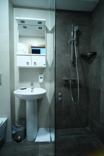 a bathroom with a sink and a shower at Hotel Pljevlja in Pljevlja