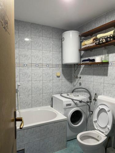 a bathroom with a washing machine and a toilet at L&L in Sarajevo