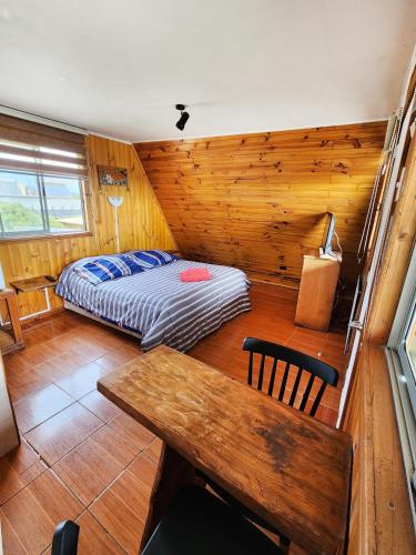 a bedroom with a bed and a table in a room at Lilafken Apart Pichilemu in Pichilemu