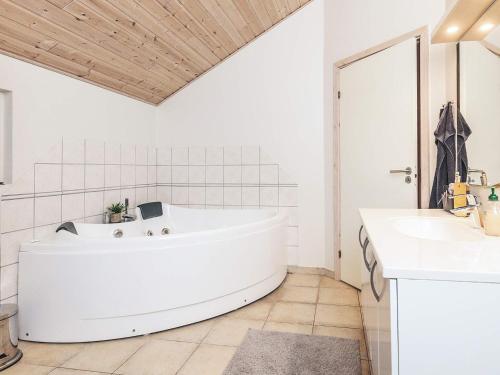 a large white tub in a bathroom with two sinks at Luxury Retreat by Kramnitze in Rødby