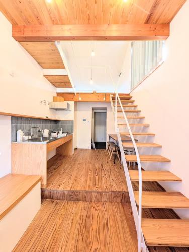 a staircase in the kitchen of a house with wooden ceilings at いなぎの木箱 in Zentsuji