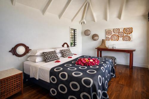 a bedroom with a black and white bed with flowers on it at Luxury Ocean View Villa, Savusavu Bay, Blue Bayou Bure with Starlink in Savusavu