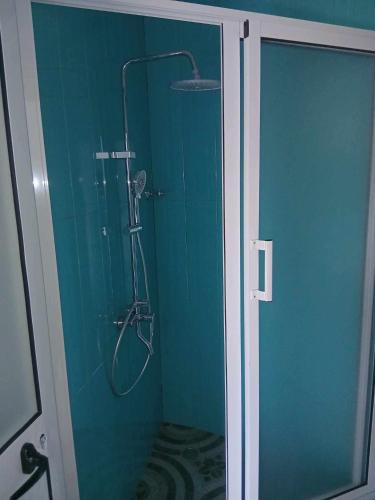 a shower in a bathroom with a blue wall at Funco Vulcao in Cova Figueira