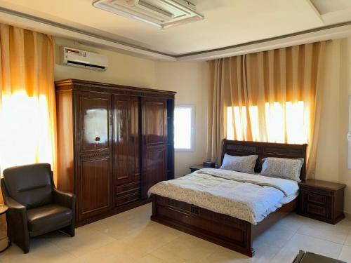 a bedroom with a bed and a chair at Ocean Gem in Bakau