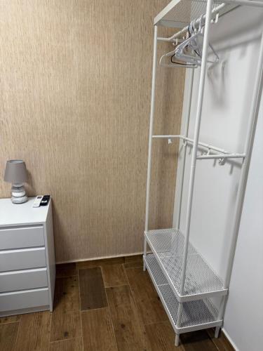 a metal shelf in a room with a white refrigerator at Hotel Mesón el 21 in Almería