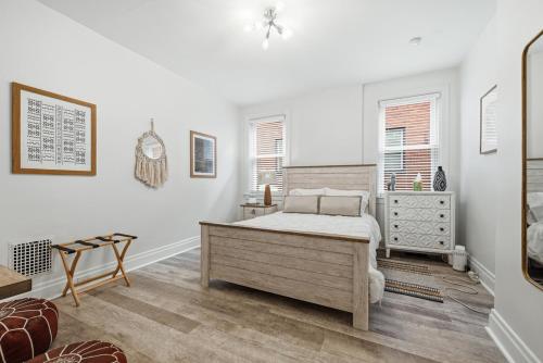 a white bedroom with a bed and a dresser at Bright & Clean 2BR Near Downtown Porch Parking in Pittsburgh