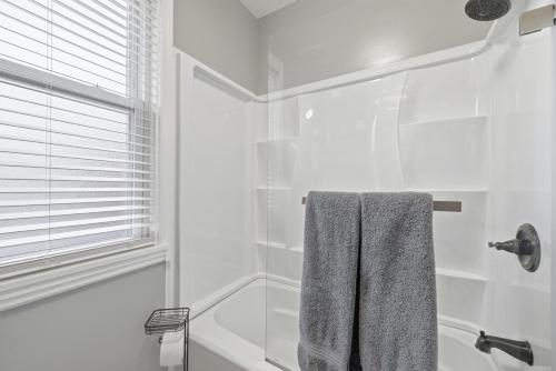 a white bathroom with a shower and a towel at Bright & Clean 2BR Near Downtown Porch Parking in Pittsburgh