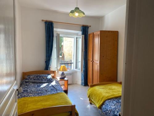 ein Schlafzimmer mit zwei Betten und einem Fenster in der Unterkunft Mountain View - 3-Bedroom, Air-Conditioned Village House in Sorède in Sorède