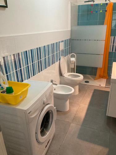 a bathroom with a washing machine and a toilet at Villa Marine Plus in Fontane Bianche