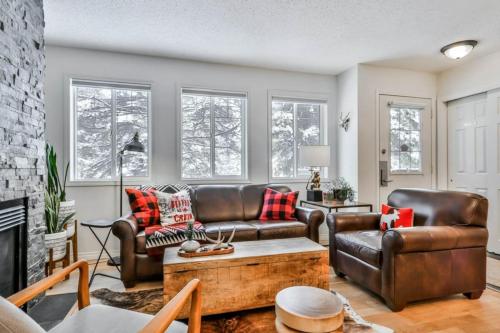 a living room with leather furniture and a fireplace at A Rustic Modern Mountain Condo - 2 bed, 2-Level in Canmore