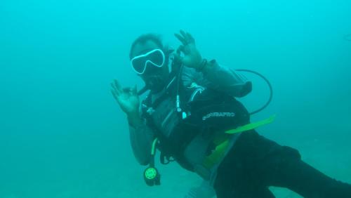 a person wearing a diving mask sitting in the water at Villa Homestay in Mesemta
