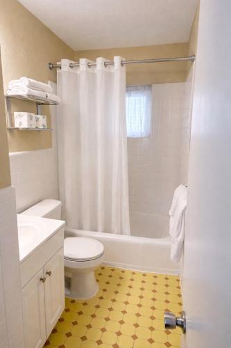 a bathroom with a white toilet and a shower at Beach Colony Motel in Wildwood Crest
