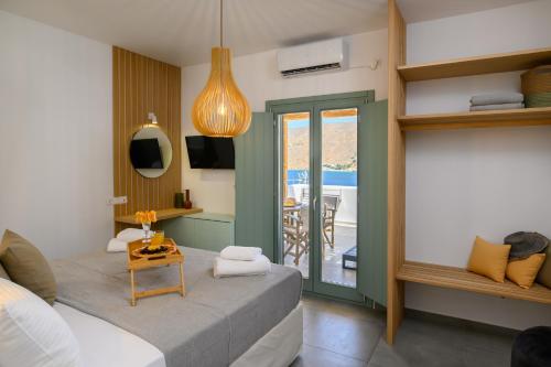 a bedroom with a bed and a table and a balcony at Le Reve in Aegiali