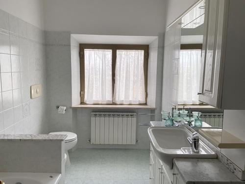a white bathroom with a sink and a toilet at Casa Erica Todi in Todi