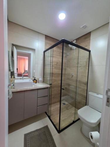 a bathroom with a shower and a toilet and a sink at Apartamento aconchegante e tranquilo in Foz do Iguaçu