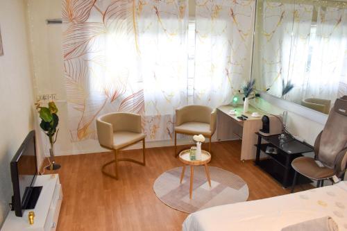 a room with two chairs and a bed and a window at Nid Dor avec Parking in Carquefou