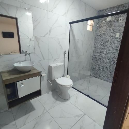 a bathroom with a toilet and a shower and a sink at Hotel Portal Triunfo in Triunfo
