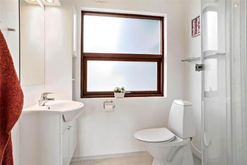 a bathroom with a toilet and a sink and a window at 30711-Odder-Skovgardsparken-1 in Odder