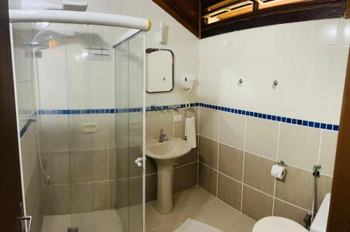 a bathroom with a shower and a sink and a toilet at Pauba Praia Hotel in Pauba