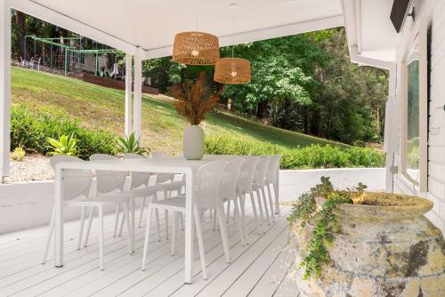 a white porch with a white table and chairs at Casa Scenic MacMasters Beach in Macmasters Beach