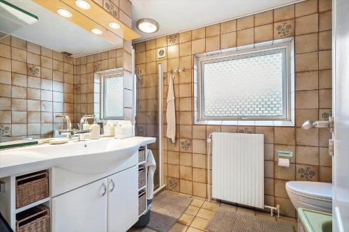 a bathroom with a sink and a toilet and a window at 10253-Ulfborg-Sognegardsvej-13 in Ulfborg