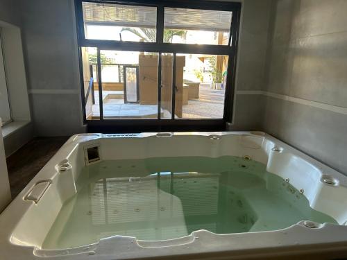 a large bath tub in a room with a window at Beach Front 2 Bed Rooms - Balcony with Full Sea View - Praia do Pepê in Rio de Janeiro