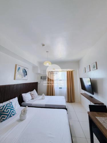 a bedroom with two beds and a television in it at Urbania Haven Cebu2 in Cebu City