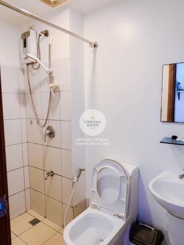 a bathroom with a toilet and a shower and a sink at Urbania Haven Cebu2 in Cebu City