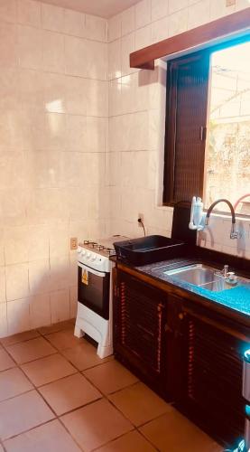 a kitchen with a stove and a sink at Refúgio do Ipê Rosa in Tubarão