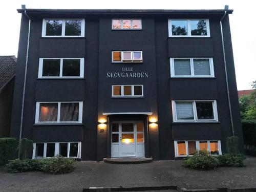a black building with a sign on the front of it at Lille Skovgaarden ved parken in Randers